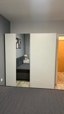 a living room with a bed and a white wall at Paradise Park Apartment Central Sofia Gem in Sofia