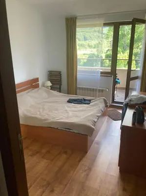 a bedroom with a bed and a large window at Ruhig in den Bergen Bulgariens in Bansko
