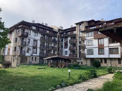 a large apartment building with a green field in front of it at Ruhig in den Bergen Bulgariens in Bansko