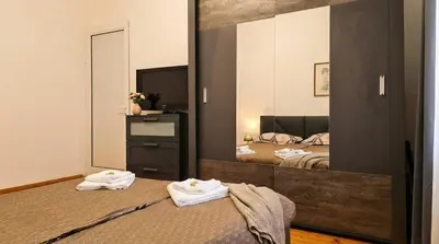 a bedroom with two beds and a large mirror at The Red Sofa City Retreat in Sofia