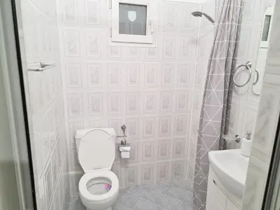 a white bathroom with a toilet and a shower at The Red Sofa City Retreat in Sofia