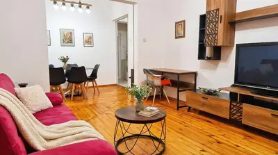 a living room with a red couch and a tv at The Red Sofa City Retreat in Sofia