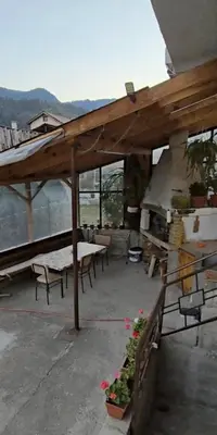 a pavilion with tables and chairs on a balcony at Къща за гости Кралимаркови Guest house Kralimarkovi in Devin