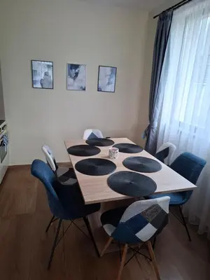 a dining room table with blue chairs around it at Къщи за гости 