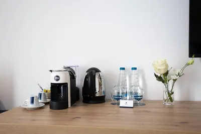 a wooden counter with a coffee maker and glasses on it at Blue Star Luxury Hotel in Sofia