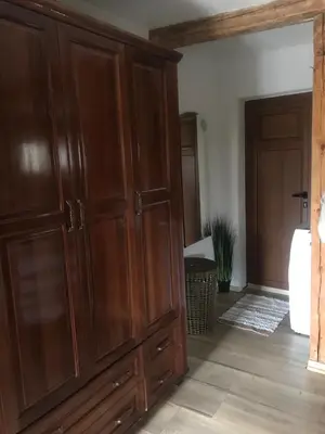 a large wooden cabinet in a room with a doorway at Books Houses in Beden