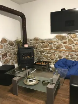 a living room with a fireplace and a stone wall at Boutique house in Devin
