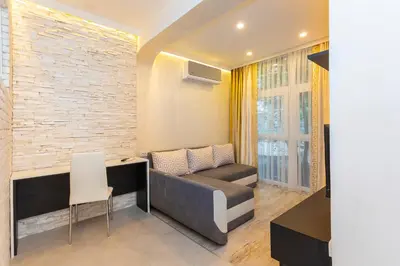 a living room with a couch and a brick wall at Central St Vitosha Apartment in Sofia