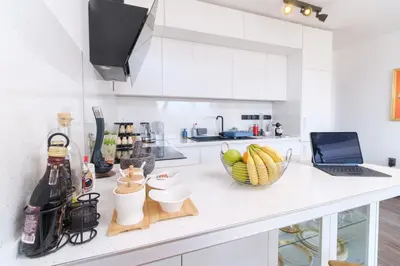a white kitchen with a bowl of fruit on a counter at Serene Luxe Oasis Retreat on the Outskirts by Flat Mаnager in Plovdiv