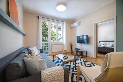 a living room with a couch and a tv at Cozy 1 bdrm, top center, Solunska near Vitoshka street in Sofia