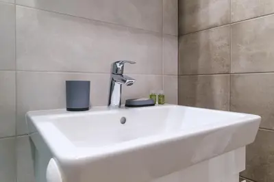 a sink in a bathroom with a faucet at Modern 1-Bedroom Apartment with Free Parking in Plovdiv