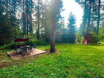 a picnic table and chairs on a wooden deck in a forest at Villa Capricorn in Tsigov Chark