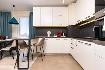 a kitchen with white cabinets and a table with chairs at Bright and Cozy 1BD Flat in Plovdiv with Parking by Flat Mаnager in Plovdiv