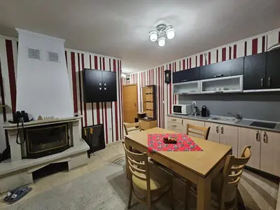 a kitchen with a table and a fireplace in it at Частен Апартамент Пампорово Гранд Манастира 2Б5 in Pamporovo