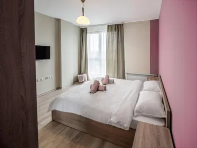 a bedroom with a bed with two pink pillows on it at The Boulevard Luxury Apartment 2 in Sofia