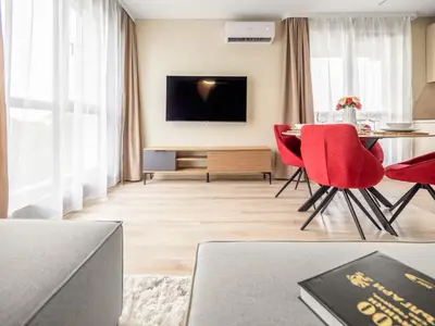a living room with a table and red chairs at The Boulevard Luxury Apartment 2 in Sofia