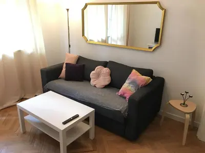 a living room with a couch and a mirror at Levski studio at heart of Sofia in Sofia