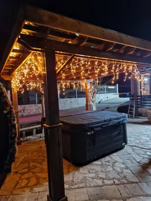 a wooden pergola with christmas lights on it at Aspen Suites Luxury apartment A005 in Razlog