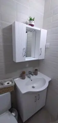 a bathroom with a sink and a mirror and a toilet at Къща Росена - стаи за гости in Devin