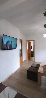 a living room with a flat screen tv on the wall at Къща Росена - стаи за гости in Devin