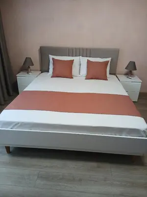 a bedroom with a large bed with two night stands at Къща Росена - стаи за гости in Devin