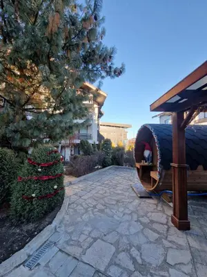 a stone walkway with a large barrel in a yard at Aspen Suites Luxury Studio A006 in Razlog