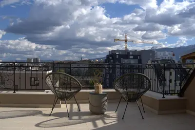 two chairs on a balcony with a view of a city at Panorama view free parking in Sofia