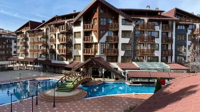 a large hotel with a swimming pool in front of it at Belvedere Holiday Club K106 in Bansko