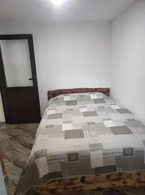 a bed with a quilt on it in a room at Къща за гости Димитрови guest house Dimitrovi in Devin