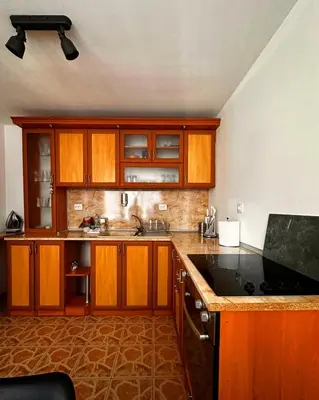 a kitchen with wooden cabinets and a black counter top at Къща за гости Димитрови guest house Dimitrovi in Devin