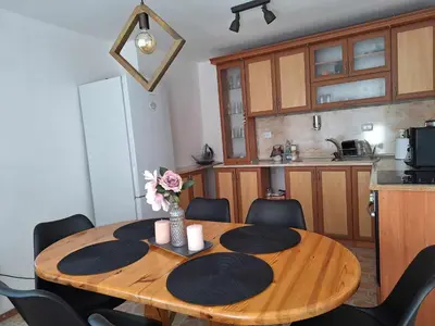 a kitchen with a wooden table with a vase of flowers on it at Къща за гости Димитрови guest house Dimitrovi in Devin