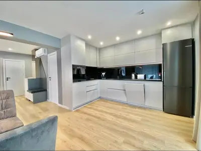 a kitchen with white cabinets and a stainless steel refrigerator at Gran Capital - Mountain View, FREE Parking in Sofia
