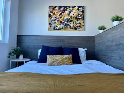 a bedroom with a bed with a painting on the wall at BOOK High Rise Studio by Cosher in Sofia