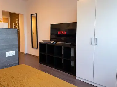 a living room with a flat screen tv and a entertainment center at BOOK High Rise Studio by Cosher in Sofia