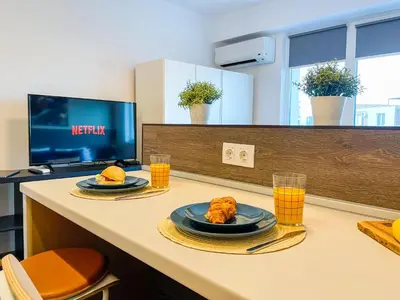 a table with two plates of food and glasses of orange juice at BOOK High Rise Studio by Cosher in Sofia