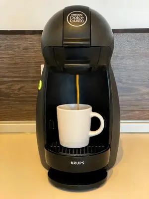 a coffee maker is making a cup of coffee at BOOK High Rise Studio by Cosher in Sofia