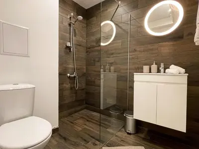 a bathroom with a toilet and a glass shower at BOOK High Rise Studio by Cosher in Sofia