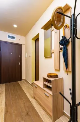 a hallway with a door and a wooden cabinet with an umbrella at Central Park Apartment Dragan Tsankov in Plovdiv