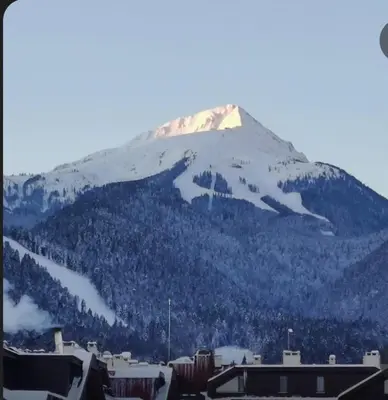 a snow covered mountain in front of a city at Guest Suite in Bansko