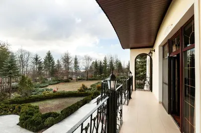 a porch of a house with a black fence at AMARI PARK Residence in Golyama Zhelyazna