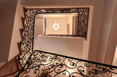 a staircase with a mirror and a wrought iron railing at AMARI PARK Residence in Golyama Zhelyazna