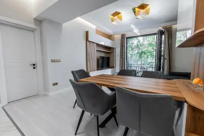 a dining room with a wooden table and chairs at Vitoshka Luxury 2-BR Retreat in Sofia