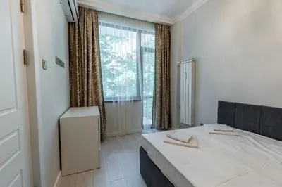 a bedroom with a bed and a large window at Vitoshka Luxury 2-BR Retreat in Sofia