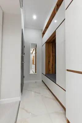 a hallway with white walls and white tile floors at Vitoshka Luxury 2-BR Retreat in Sofia