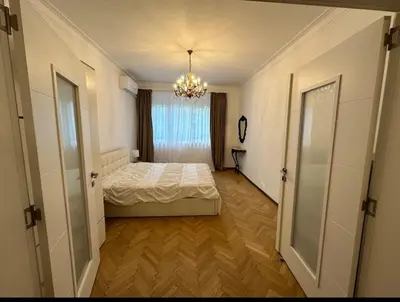 a bedroom with a bed and a chandelier at Apartament 86 in Sofia