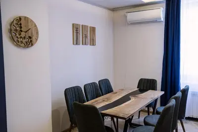 a dining room with a table and chairs and a clock at 3BDR, Top Center Retreat, Sofia Heart, FREE Parking in Sofia