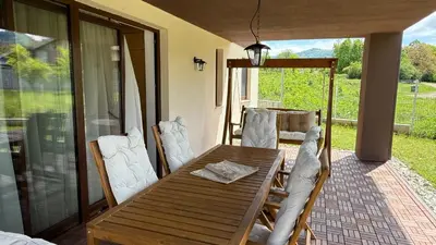 a wooden table and chairs on a patio at Edelweiss Oreshak in Oreshak