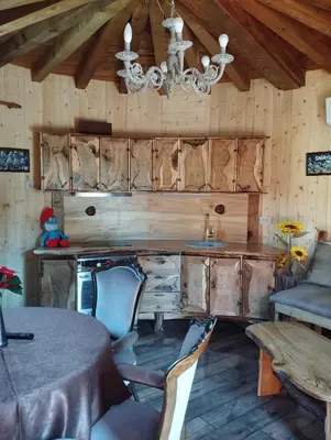 a kitchen with a table and chairs and a chandelier at Приказната къщичка на Смърфовете in Krayni Dol
