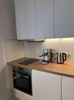 a kitchen with white cabinets and a counter top at Aristocratic apartment with a parking spot in Sofia