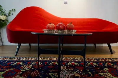 a red couch with two vases on a table at Aristocratic apartment with a parking spot in Sofia